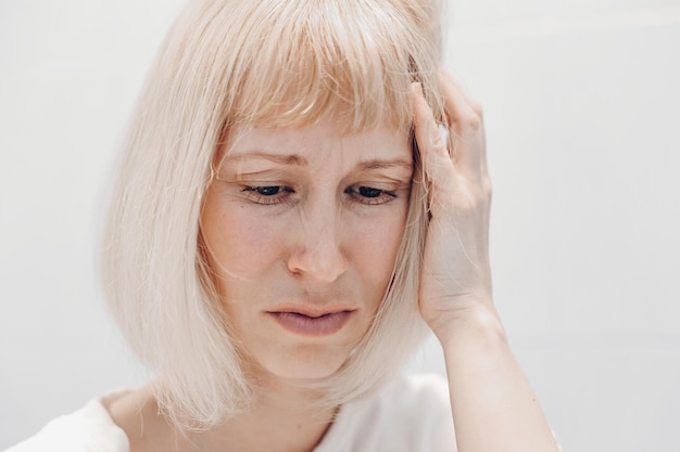 Portret van een noodlijdende vrouw op een witte achtergrond