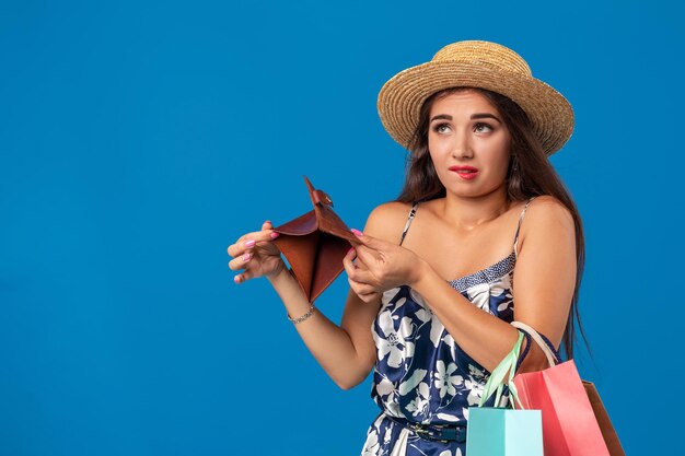 Portret van een ongelukkige jonge vrouw die in haar portemonnee in het winkelcentrum kijkt, te veel uitgegeven, niet genoeg geld, geld verloren, kapot