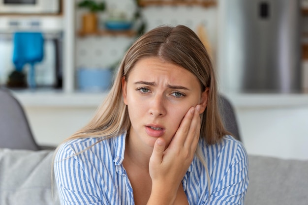 Portret van een ongelukkige vrouw die thuis lijdt aan kiespijn Gezondheidszorg, tandheelkundige gezondheid en probleemconcept Stockfoto