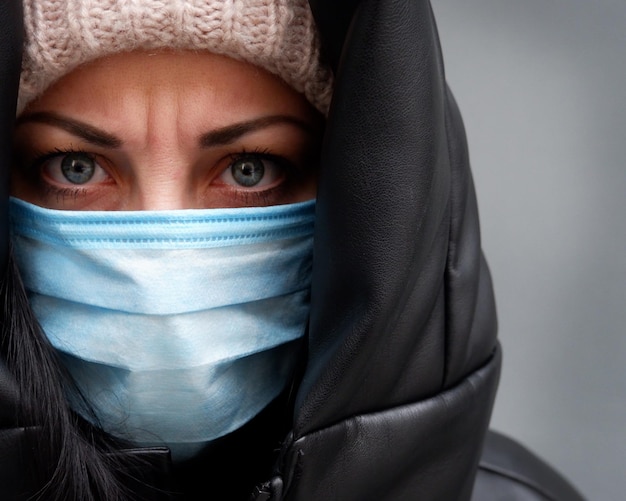 Portret van een ongelukkige vrouw met een masker om het virus of de vervuiling te bestrijden
