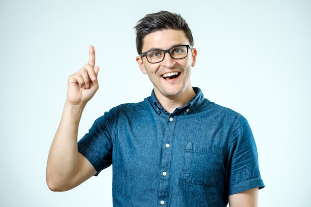 Portret van een opgewonden gelukkig man wijzende vinger weg op kopie ruimte
