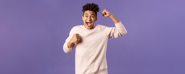 Foto portret van een opgewonden, gelukkige man die zijn team een doelpunt ziet maken op een sport-tv-zender die zingt, verhoog een ha