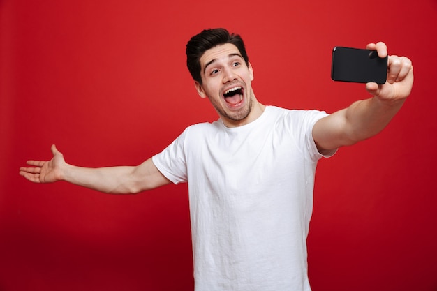 Portret van een opgewonden jonge man in wit t-shirt