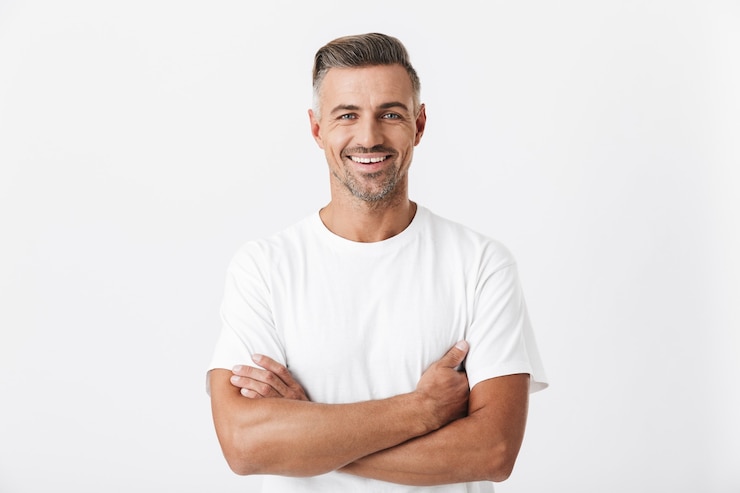 Foto portret van een optimistische man van de jaren '30 met haren die een casual t-shirt dragen dat zich voordeed op wit wordt geïsoleerd