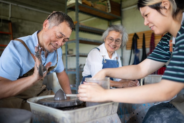 Foto portret van een ouder aziatisch echtpaar dat samen activiteiten uitvoert in de pottenbakkerswerkplaats