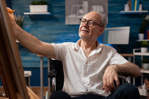 Foto portret van een oudere man die in een werkplaats zit