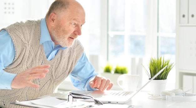 Portret van een oudere man met een laptop