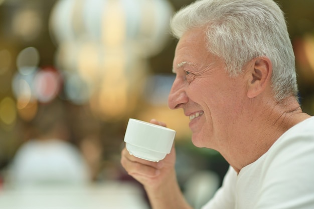 Portret van een oudere man met kopje koffie