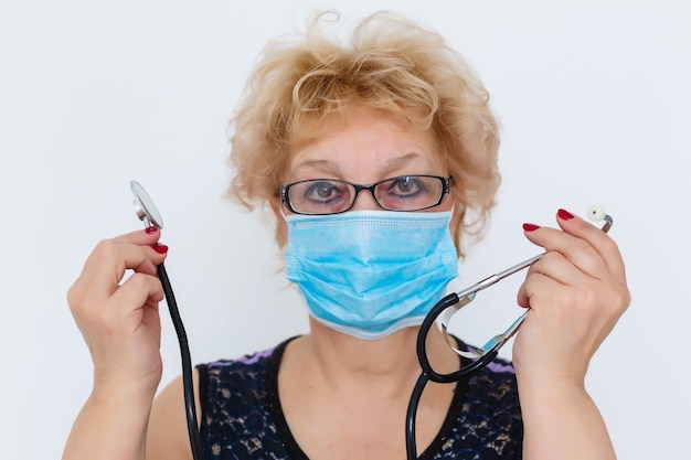 Portret van een oudere vrouw die een masker draagt met een stethoscoop