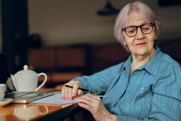 Portret van een oudere vrouw die in een café zit met een kopje koffie en een laptop Sociale netwerken ongewijzigd