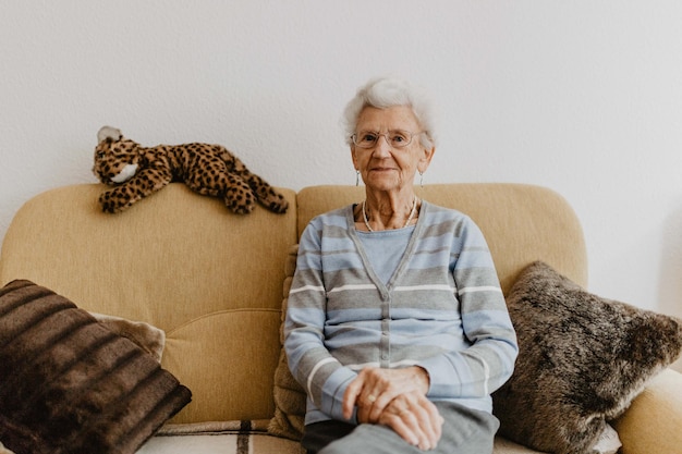 Foto portret van een oudere vrouw die thuis op de bank zit