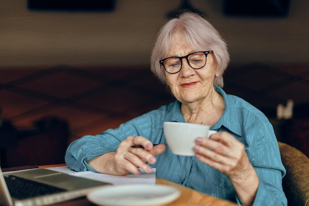 Portret van een oudere vrouw documenteert werkblad van papier en pen Gepensioneerde vrouw die ongewijzigd aan het chatten is