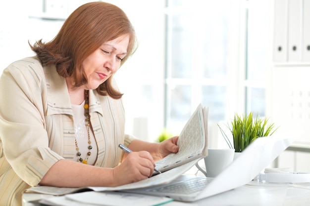 Portret van een oudere vrouw met een laptop