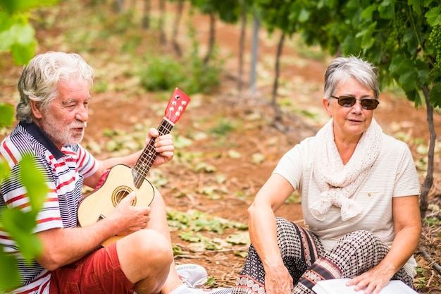 portret van een paar oudere oudere volwassenen die samen op het platteland blijven en genieten van de vrijetijdsmuziekactiviteit