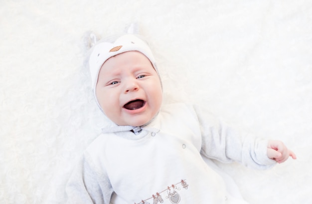 Portret van een pasgeboren baby in een hoed met oren op een wit