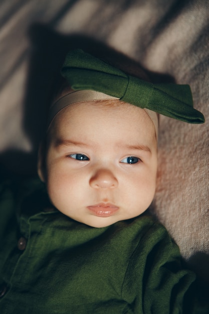 Portret van een pasgeboren kind met een groene strik