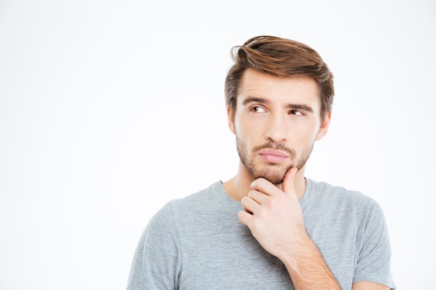 Portret van een peinzende casual man die geïsoleerd op een witte achtergrond staat