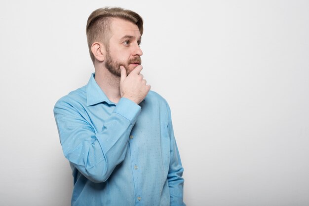 Portret van een peinzende zakenman zijn kin over wit aan te raken