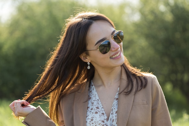 Portret van een positief vrolijk brunette meisje in een groen lentepark.