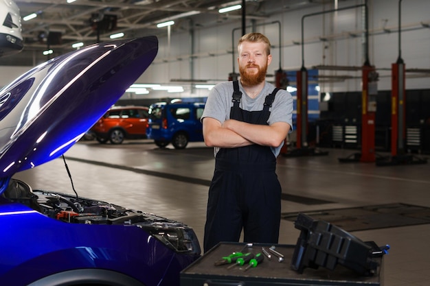 Portret van een professionele automonteur in een schoon uniform tegen de achtergrond van een modern autoreparatiecentrum