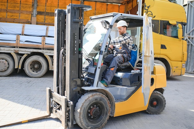 Foto portret van een professionele heftruckchauffeur in het magazijn van een fabriek