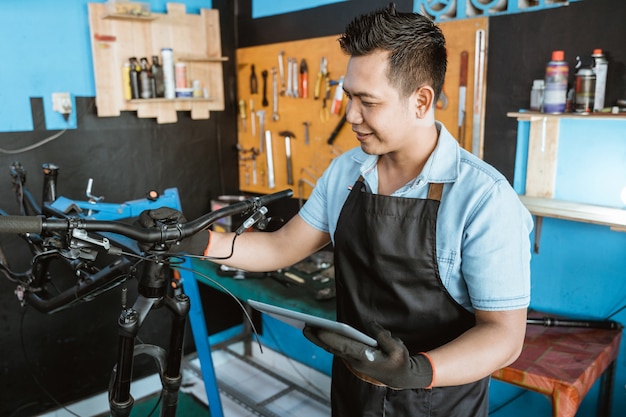 Portret van een reparateur in een schort als werkkleding die een tablet gebruikt om te repareren