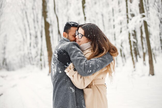 Portret van een romantisch stel dat samen tijd doorbrengt in het winterbos