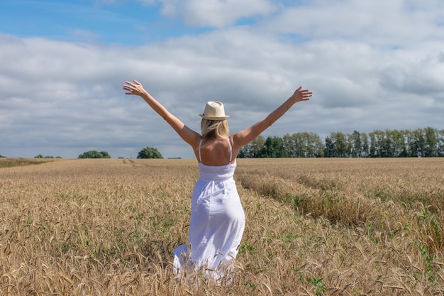 Portret van een romantische vrouw die van achteren over het veld rent