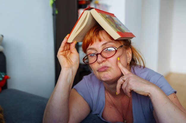 Portret van een roodharige vrouw die een roman leest