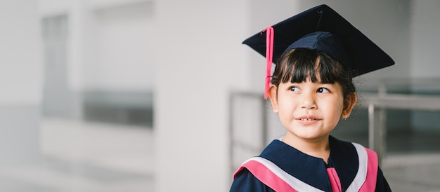 Portret van een schattig Aziatisch afgestudeerd schoolmeisje met afstudeerjurk op school