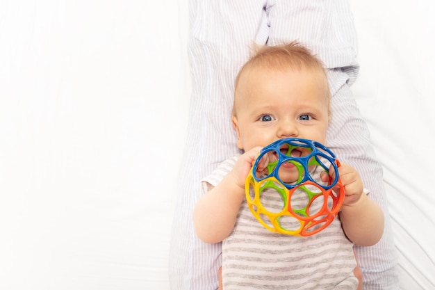 Portret van een schattig baby meisje met een speelgoed op een witte achtergrond