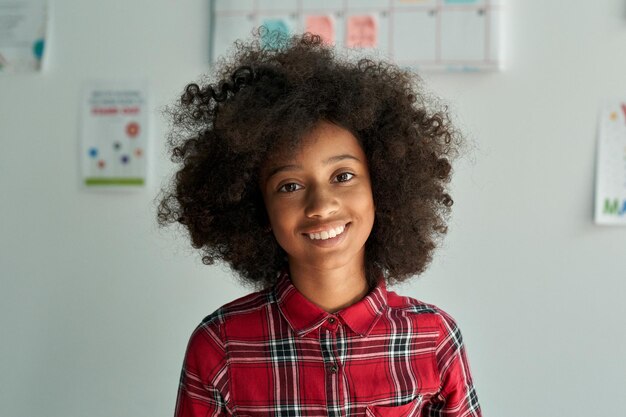 Portret van een schattig glimlachend afro-Amerikaans schoolmeisje dat in de klas staat