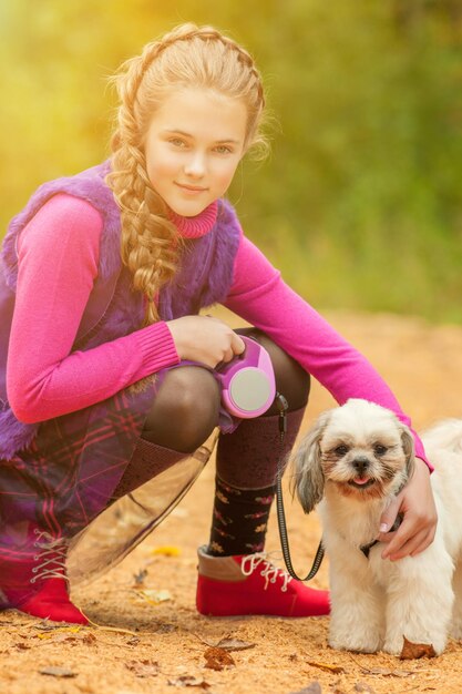 Foto portret van een schattig klein meisje dat met een hond poseert