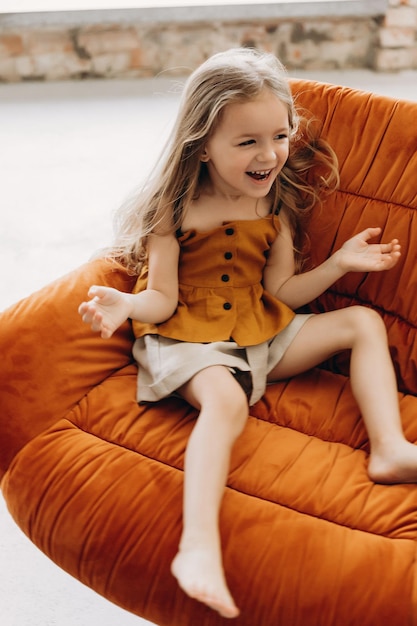 Portret van een schattig klein meisje dat poseert voor een foto in een lichte studio Het meisje lacht en heeft plezier