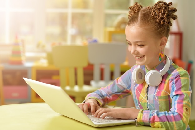 Portret van een schattig klein meisje met behulp van laptop