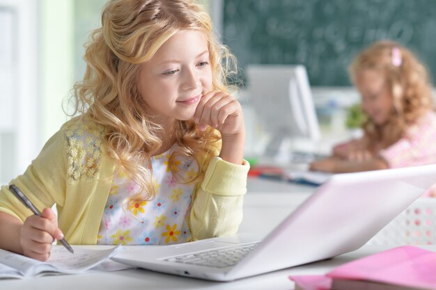 Portret van een schattig klein meisje met behulp van laptop