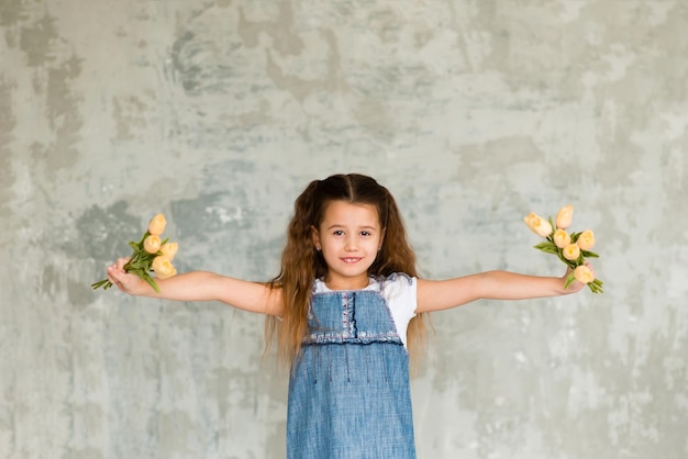 Portret van een schattig klein meisje met bloemen. Lente portret. Moederdag.