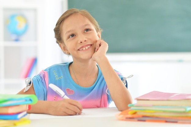 Portret van een schattig klein meisje tekenen terwijl ze thuis aan tafel zit