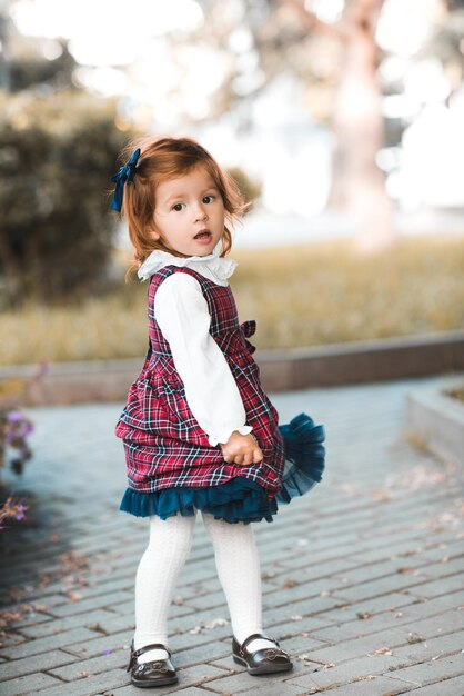 Foto portret van een schattig meisje dat in het park staat