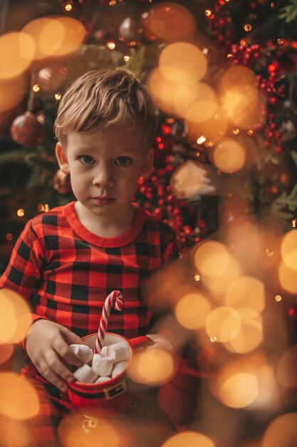 Portret van een schattig meisje dat's nachts een kerstboom versiert
