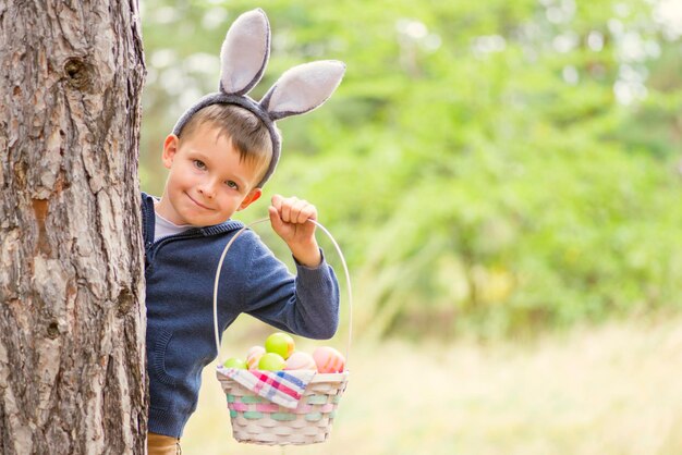 Foto portret van een schattig meisje dat tegen een boom staat