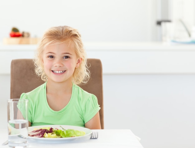 Portret van een schattig meisje het eten van een gezonde salade voor de lunch