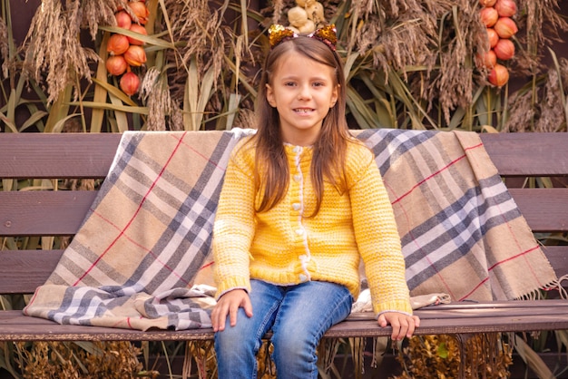 Foto portret van een schattig meisje in warme kleren in herfst halloween concept