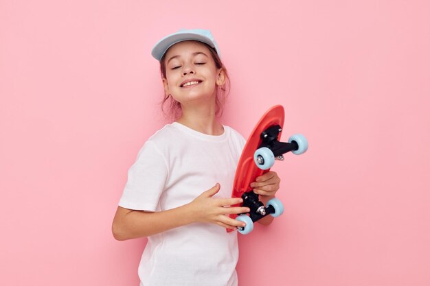 Foto portret van een schattig meisje met dumbbells op een roze achtergrond