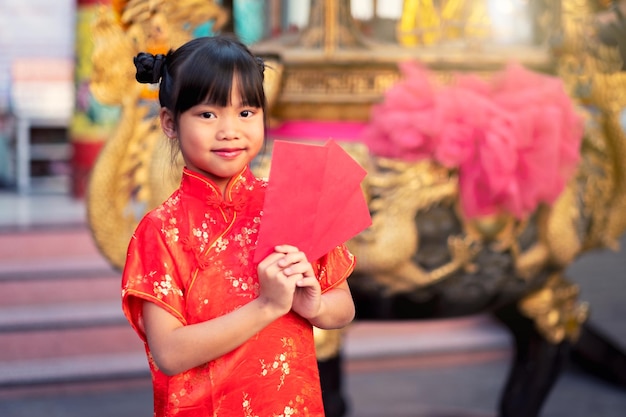 Portret van een schattig meisje met een rode envelop tijdens het Chinese Nieuwjaar