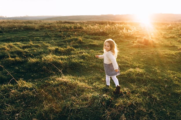 Portret van een schattig mooi en gelukkig meisje loopt door het zonnige veld