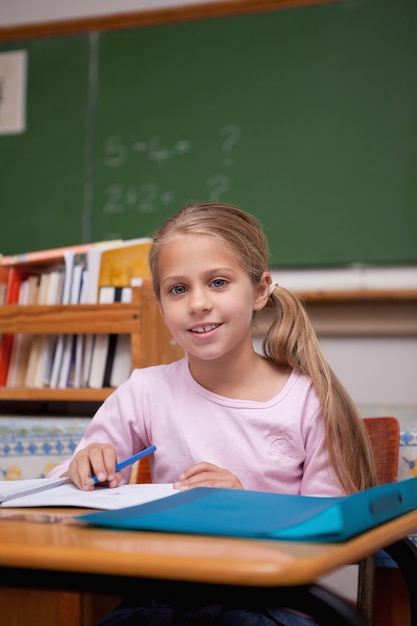 Portret van een schattig schoolmeisje schrijven