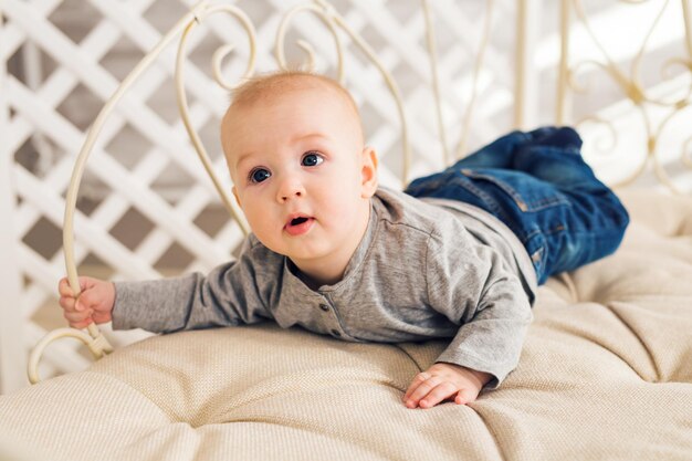 Foto portret van een schattige baby die op het bed ligt
