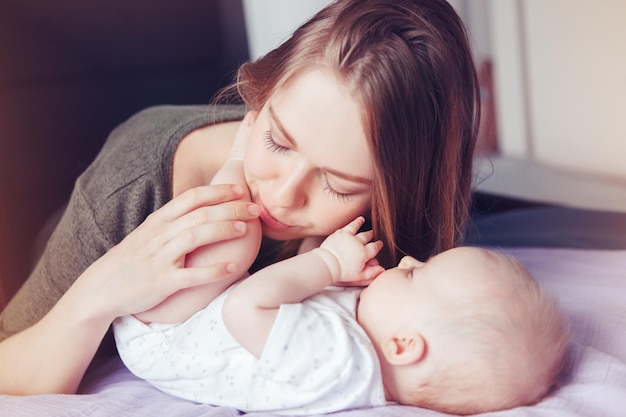 Foto portret van een schattige baby die thuis op bed ligt