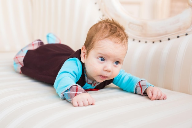 Foto portret van een schattige baby die thuis op bed ligt